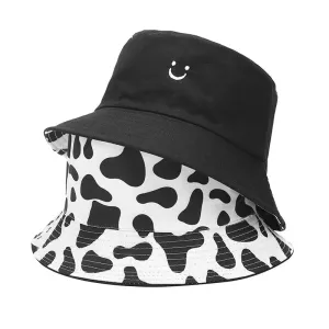 Black & White Cow Print Reversible Bucket Hat boater hat with bow in beach sunlight