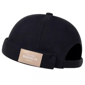 Brooklyn 1947 Black Docker Cap boater hat with bow in beach sunlight